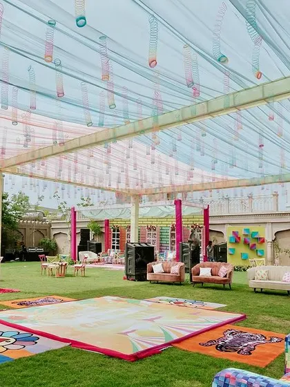 A wide shot of the carnival-style Mehendi, showing the colorful dance floor, eclectic furniture, and various fun zones designed for guest enjoyment.