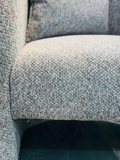 A close-up shot of the textured grey-blue fabric used on our contemporary armchair, highlighting the quality and durability of the materials we select.