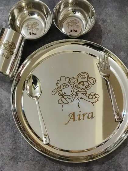 Make mealtime fun with a personalized stainless steel dinner set for kids. This one is engraved with the name 'Aira' and a cute 'Shaun the Sheep' design.