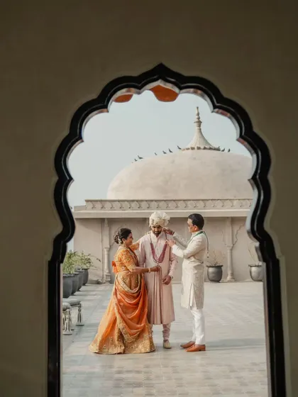 A precious moment between the groom and his parents, framed by a traditional archway at the Fairmont Jaipur.