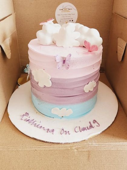 The story of a rainbow cake. This cake features a beautiful pastel ombre of pink, purple, and blue, topped with fluffy fondant clouds.