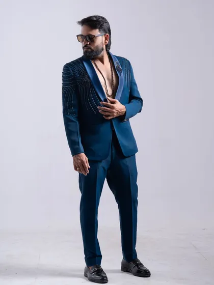 I offer a sharp collection of men's suits for any occasion. This modern teal suit features unique shoulder embellishments, perfect for grooms, event attendees, or a stylish profile shoot.