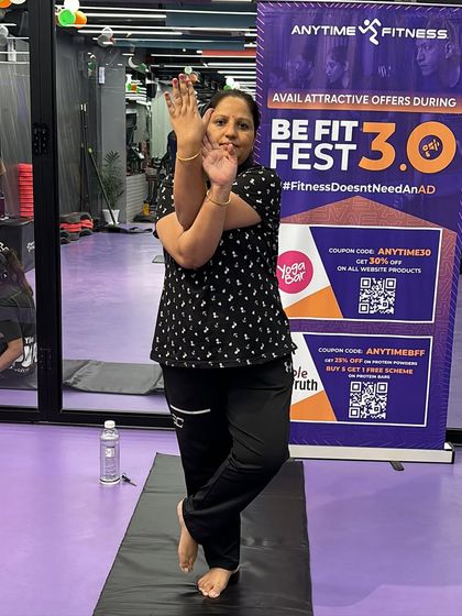 This participant holds the Eagle Pose with a steady gaze, a key technique for maintaining balance that we teach in our classes.