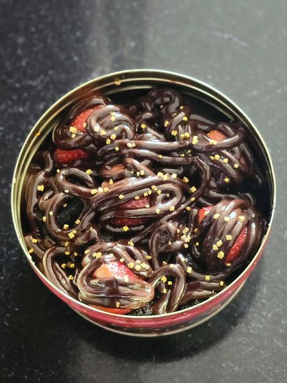 The finished chocolate and strawberry creation, all packed in a convenient tin. The combination of rich chocolate, fresh fruit, and crunchy sprinkles makes for a dessert with wonderful textures and flavors.