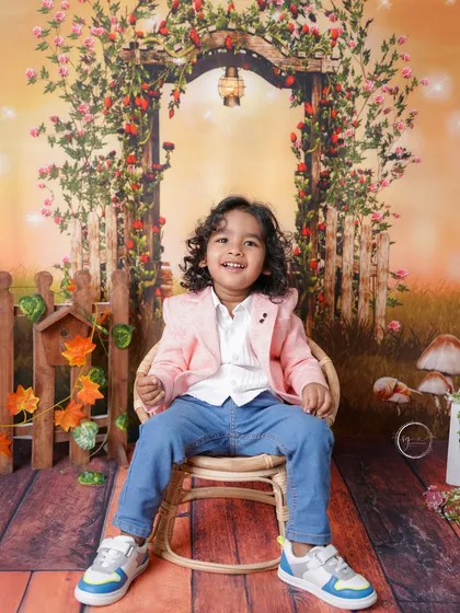 A full, happy smile that shows he's having a great time during his second birthday photoshoot.