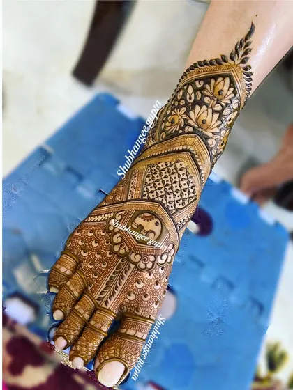 A simple yet elegant bridal foot design. This piece focuses the detail on the top of the foot, with a central peacock motif and a lighter pattern extending towards the ankle.