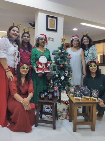 The entire group from the Christmas art party posing with their creations, capturing the festive spirit and shared accomplishment.