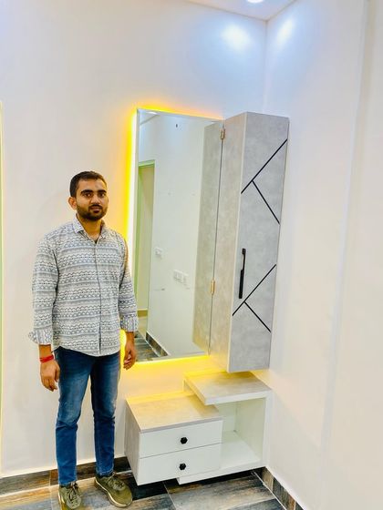 This dressing unit features a backlit mirror and a floating console with a vertical storage cabinet, all in a modern white and grey finish.