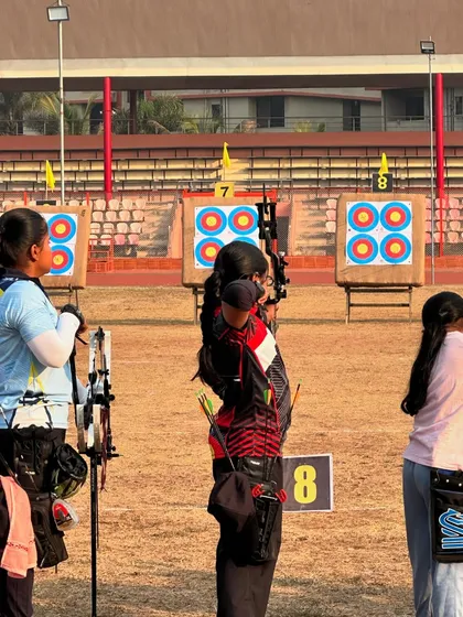 A young archer on the shooting line, focusing on the target during a competitive match. This is where practice meets performance.
