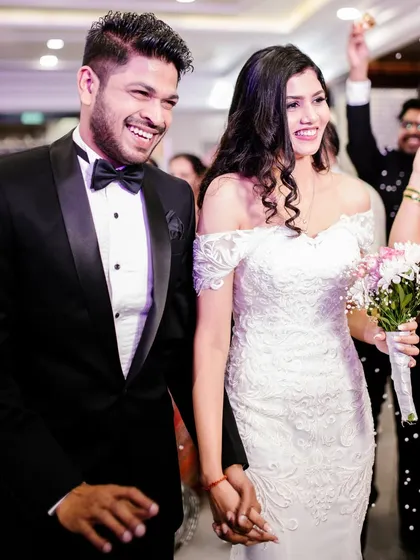 A joyful exit shot of the happy couple. The bride's makeup is flawless and radiant, ensuring she looks perfect from the first dance to the final farewell.