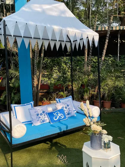 A closer look at the custom daybed, showing the personalized cushions and the elegant white canopy.
