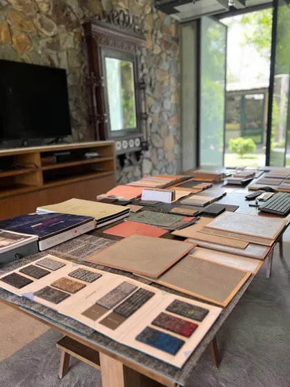 Material selection is a thoughtful conversation. Here in our studio, we lay out samples of carpets, laminates, and veneers to see how they interact, asking how they will evolve, what mood they will set, and how they will feel in the real space.