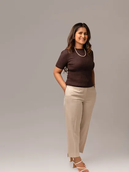 This full-length portrait shows a more relaxed yet professional look. It’s a great option for a website's 'About Me' page, giving a complete picture of her confident and approachable style.