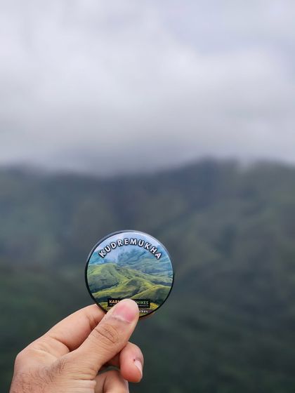 Our Kudremukha trek badge, a small souvenir to remember the big adventure, held up against the misty hills.