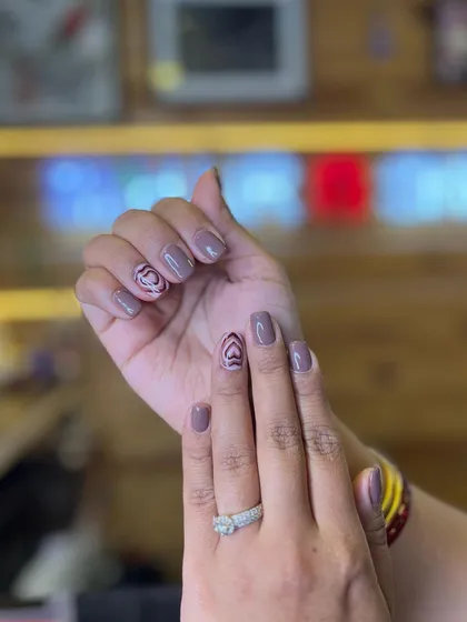 Another view of the trendy brown heart nail art. This shows how an accent nail with a graphic design can elevate a simple manicure into a personalized style statement.