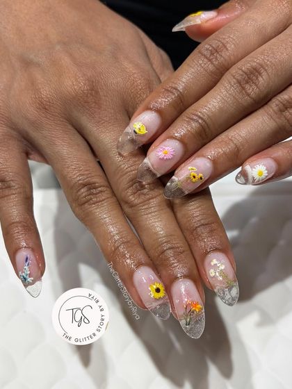 Another angle of the encapsulated floral nail art, showing the variety of tiny flowers and delicate silver foil used to create this garden-on-your-nails look.