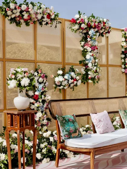 A close-up of the floral decor on the cane-paneled backdrop, showing the beautiful combination of textures and colors.