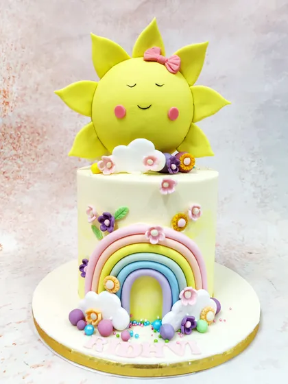 This Rainbow Sun Cake is a burst of happiness, featuring a smiling sun topper and a sweet pastel rainbow on the front.