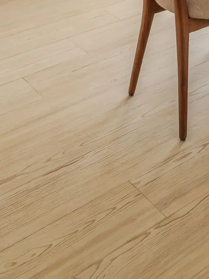 The grain of the wood, the leg of a chair. Sometimes the simplest details are the most beautiful. This close-up highlights the natural texture of the light wood flooring, a foundational element that brings warmth and character to a room.