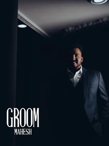 A classic portrait of the groom, looking dapper and ready for his reception. The dark, moody lighting adds a touch of drama and style.