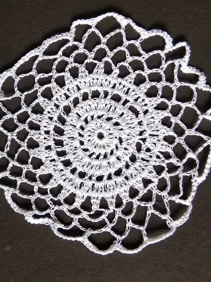 An 8-inch white crochet doily.