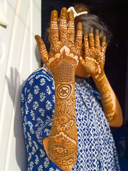 A playful pose showing off the Marvel-themed bridal henna.