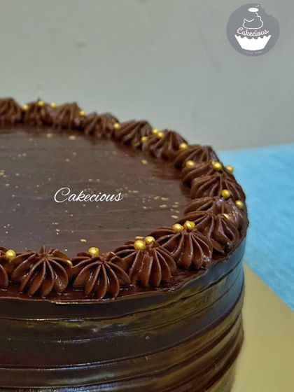 A close-up shot of my tempting Belgium Chocolate cake. The glossy ganache and delicate gold sprinkles make it irresistible.