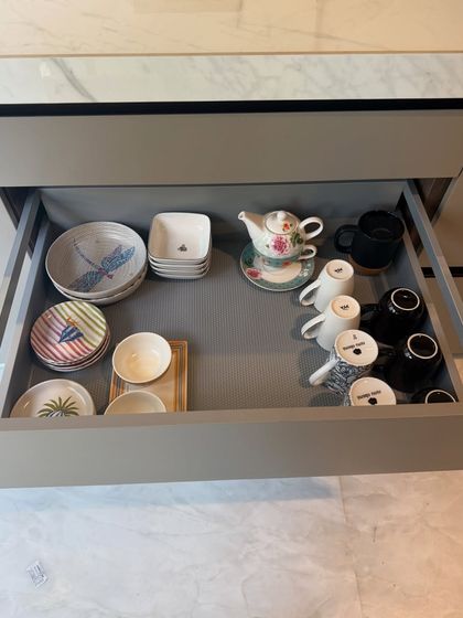 Even a drawer with miscellaneous items can be organized. Here, we've grouped plates, bowls, and a teapot in a way that feels intentional and clutter-free.