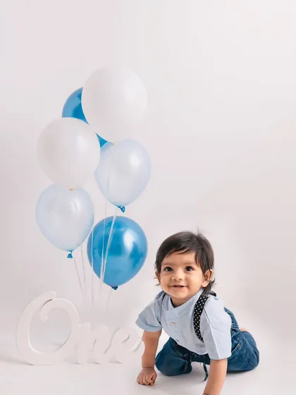 This little crawler is on a mission! A simple and clean setup with blue and white balloons for a classic first birthday look.