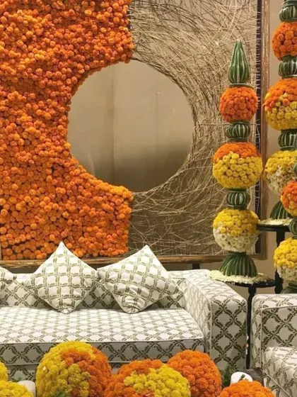 This is a contemporary take on marigold decor. The clean circular cutout in the floral wall and the geometric marigold spheres add a modern, artistic touch.