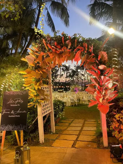 A rustic-chic entrance for a cocktail party. The arch is decorated with dried pampas grass and warm-toned foliage, setting a stylish and relaxed mood for the evening.