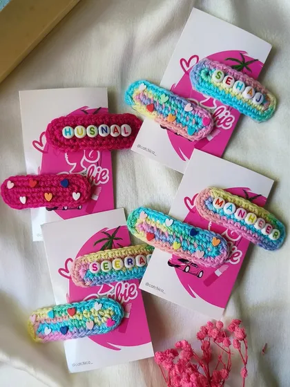 A closer look at some of our custom name clips. You can see the detail in the rainbow crochet for 'Sehaj' and 'Maneer' and the solid pink with hearts for 'Husnal'.