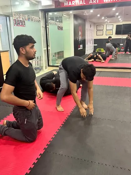 Students partner up for drills at the start of a grappling session. These exercises are designed to build foundational skills and prepare the body for more complex techniques.