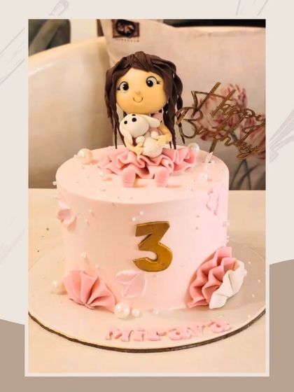 A charming pink cake for a 3rd birthday, featuring a cute fondant girl holding her bunny and origami-style fans.