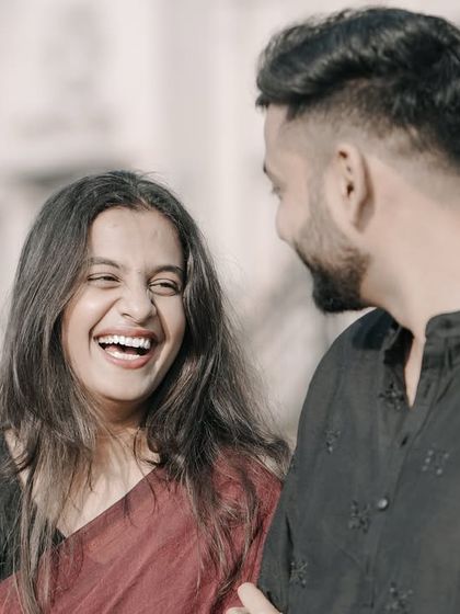 A joyful, laughing close-up of a couple, capturing a moment of pure happiness during their urban pre-wedding shoot.