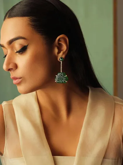 A profile shot showcasing magnificent carved emerald Art Deco earrings. This demonstrates my expertise in jewelry styling to complement a client's features and outfit.