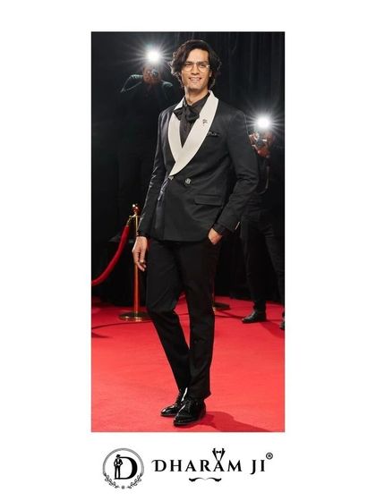 A black suit with a contrasting white lapel, perfect for a black-tie event. This design offers a modern twist on the classic tuxedo.