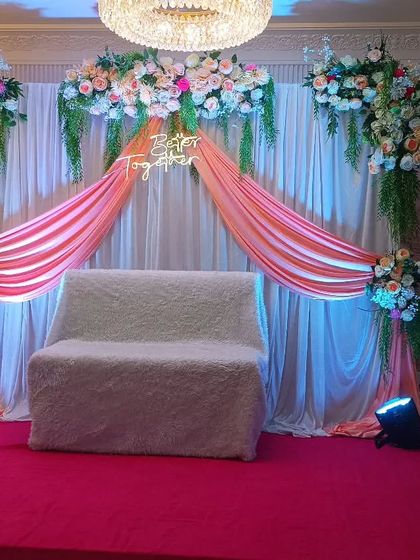 A wider view of the peach-themed engagement decor, showing the full stage on a red carpet. This demonstrates how our setups can transform a simple hall space.