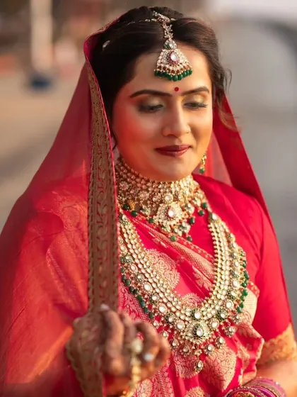 This bride's look was all about royal elegance. The makeup features a classic winged liner and a bold lip, paired with a traditional red saree and heavy jewelry for a truly regal appearance.