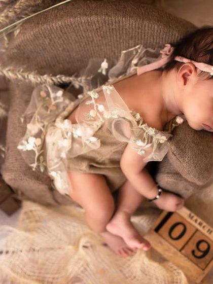 An overhead shot of the same setup, showing the baby on the miniature sofa with a vintage-style telephone prop. Every detail is thoughtfully placed.