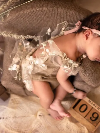 An overhead shot of the same setup, showing the baby on the miniature sofa with a vintage-style telephone prop. Every detail is thoughtfully placed.