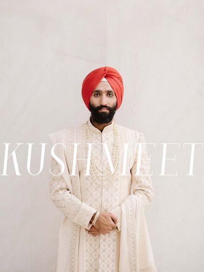 A classic, minimalist portrait of the groom, Kushmeet. The clean white background and his direct gaze create a strong and modern image, highlighting his sharp red turban.