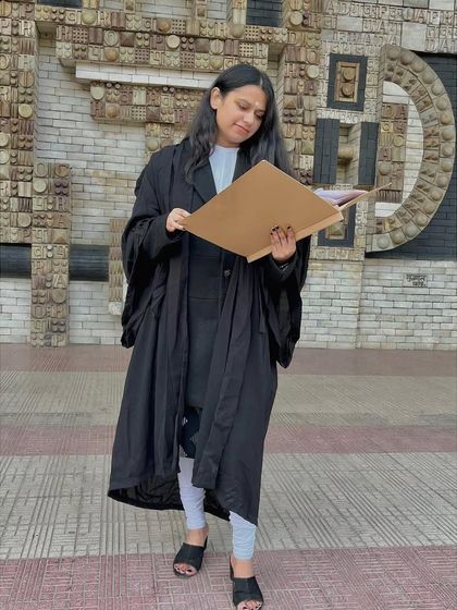 Reviewing a case file outside the Delhi High Court. Thorough preparation is key, and I make sure to be fully prepared before every hearing to best represent your interests.