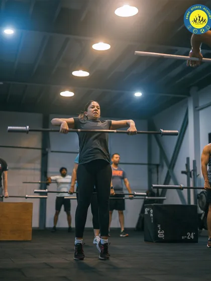 A group of athletes works on their upright row technique with barbells. This exercise is fantastic for building shoulder and upper back strength, and doing it in a group keeps the energy high.