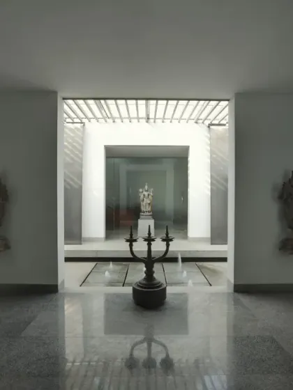 A symmetrical and serene courtyard space at an office in Coimbatore. The design uses water, sculpture, and reflected light to create a formal yet tranquil entry sequence, establishing a sense of balance and order.