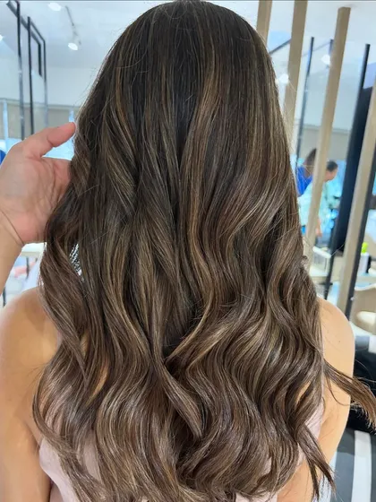 A cool beige blonde highlight blend created with a balayage technique. This is a great way to achieve a lighter look while maintaining a natural, blended root.