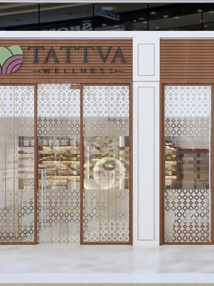 The storefront design for Tattva Wellness, a spa where serenity begins at the entrance. We used wood and intricate jali patterns on the glass to create a sense of calm and privacy.