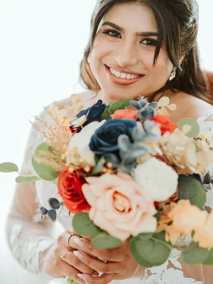 A close-up of the bride's happy smile and her beautiful bouquet.