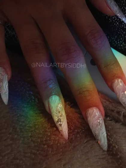 A beautiful shot of the stiletto nails under a rainbow light, highlighting the internal design.