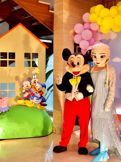 Mickey Mouse and Queen Elsa mascots posing for a photo. I can arrange for a variety of popular character appearances to match your child's favorite shows and movies.